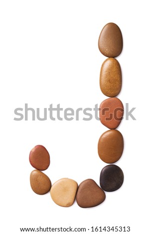 Letter J made of marine small pebbles, top view. Alphabet made of stones Isolated on a white background
