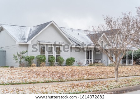 Typical bungalow house under winter snow cover near Dallas, Texas. Middle class residential home in America.