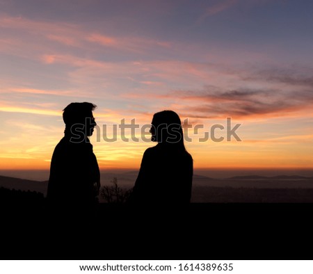 Silhouette couple looking to each other