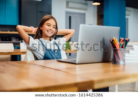 First day at school. Cute and happy little girl children using laptop computer, studying through online e-learning system. Royalty-Free Stock Photo #1614425386