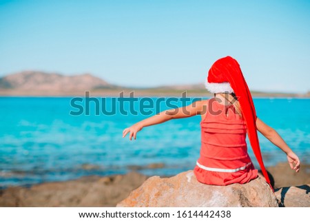 Back view of little girl on New Year vacation on the beach