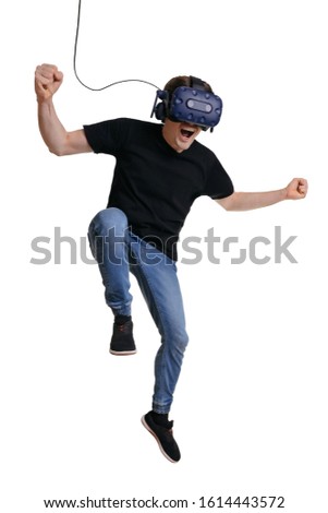 Happy man in VR glasses is screaming and making winner gesture. Concept of human emotions,facial expression, modern gadgets and technologies. Male in 3d headset is dancing isolated on white background
