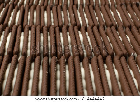 Soft chocolate butter cookie with white creamy filling texture background. Brown quadratic soft biscuits, square cookies or fresh sweet cocoa buns closeup