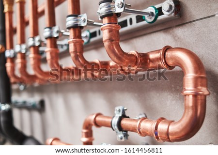Plumbing service. copper pipeline of a heating system in boiler room Royalty-Free Stock Photo #1614456811