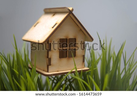 Wooden house model on artificial grass floor. Property investment and house mortgage concept. empty Copy space for inscription.