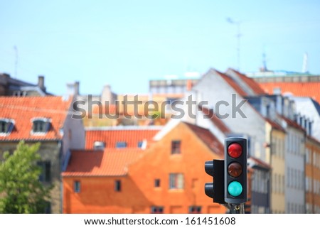 Green color on the traffic lights against city background