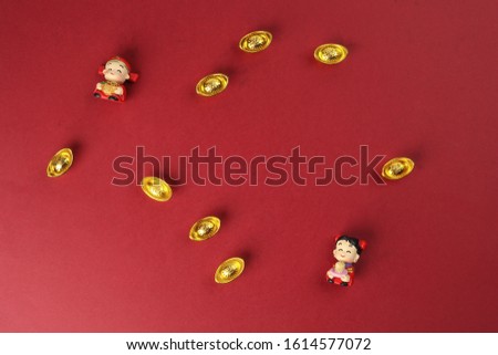 Chinese boy girl doll figurine money syce ingot gold on red background copy space Chinese alphabet on both dolls meaning Happiness 