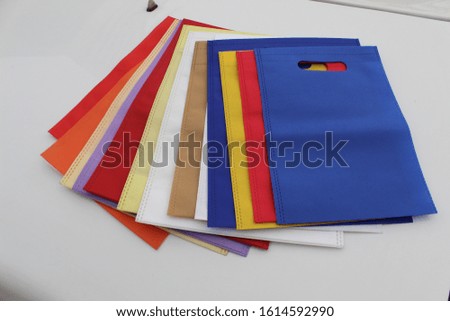 Assorted colored shopping bags including red, yellow, lime green, orange, pink and blue on a white background