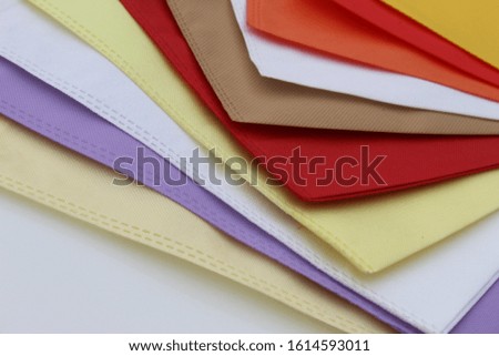 Assorted colored shopping bags including red, yellow, lime green, orange, pink and blue on a white background