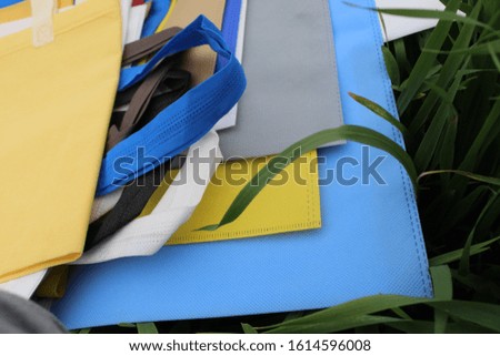 zero waste shopping with textile bags on green background. plastic free concept. flat lay. Non Woven Fabric Shopping Bags isolate on green grass background