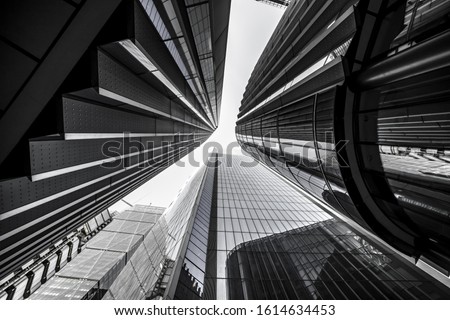 A low angle greyscale of modern skyscrapers with glass windows under sunlight Royalty-Free Stock Photo #1614634453