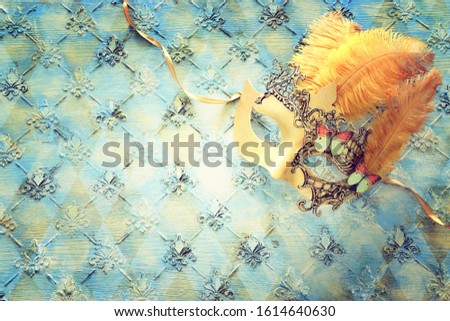 Gold elegant traditional venetian mask over vintage wooden background