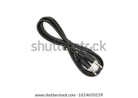 Standard 3.5mm Male to Male audio cable. Tied with a twist tie. Top view shot. Royalty-Free Stock Photo #1614650539