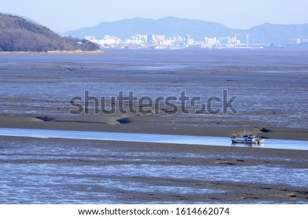 skyblue colored mudflats in the ganghwado island of korea republic. rocks and sand images of the dongmak beach of korea republic.