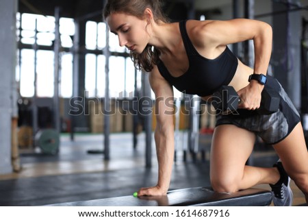 Muscular fit woman exercising building muscles at gym.