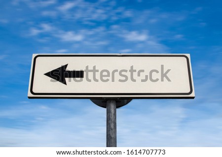 Blank white left directional arrow sign on blue. White road sign with arrow on blue sky with clouds background. Left pointing direction sign with space for text. Blanked for your own message.