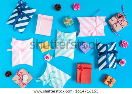 A various of a gift box, small pink rose and pine cones placed spread around the picture on blue background,Valentine's day and birthday concept
