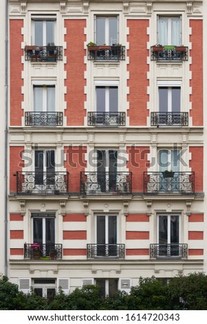 facade of Parisian Haussmann building red brick coated white in cloudy weather rain without deformation perspective
