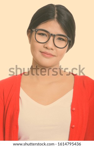 Face of young beautiful Asian nerd woman with eyeglasses
