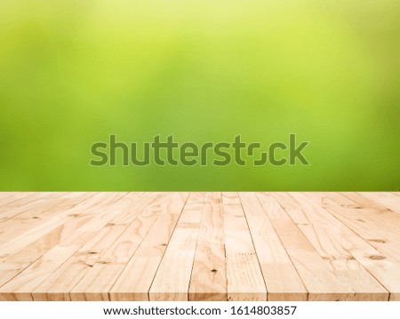 Real wood table top texture on blur fresh green garden background.For create product display or design key visual layout
