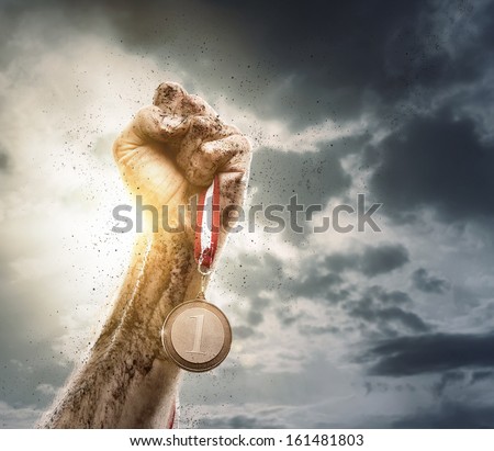 Success concept, male hand rise up a gold medal against the dramatic sky with copy space Royalty-Free Stock Photo #161481803