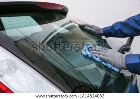Male worker tinting car window