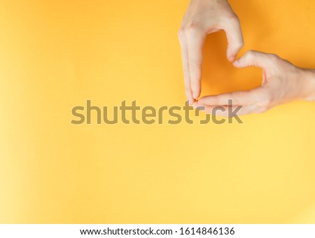 Yellow paper background. Medical issue and protection of human rights. A man's heart. Crossed arms in uniform. 