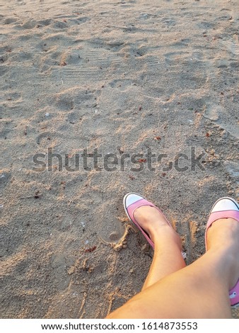 Woman feet sitting on the beach alone