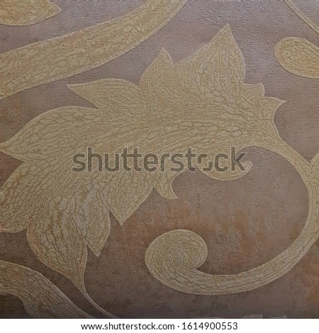 Brown ceramic tile with leaves pattern for wall decor. Concrete stone surface background. Texture for interior design project.
