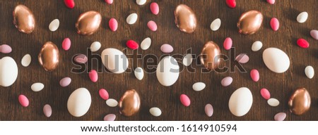 Flat Lay of Golden and multi-color Easter Eggs Pattern on wooden background. Easter background or easter concept. Happy Easter