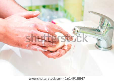 a man washes his hands with soap