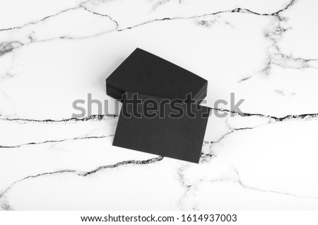 Photo of black business cards on white marble. Template for branding identity isolated on marble background. Marble premium luxury mock-up. Business Card isolated on marble stone.