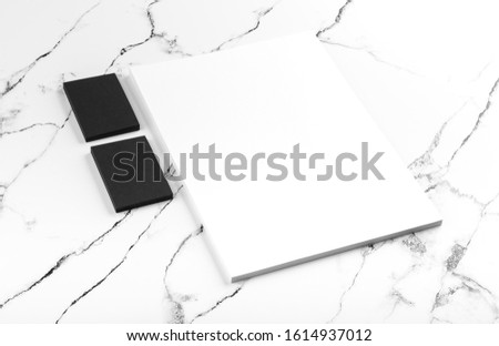 Photo of black & white branding identity mock up on white marble. Template isolated on marble background. For graphic designers presentations and portfolios marble premium luxury mock-up
