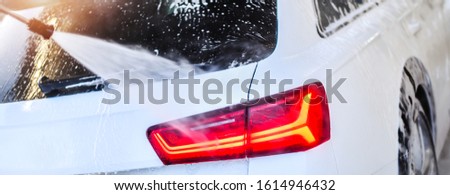 Car Wash Business detail. Washing luxury Car with Copy Space. Wide banner or panorama picture.
