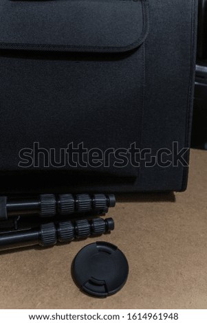 A vertical shot of camera equipment near a black bag