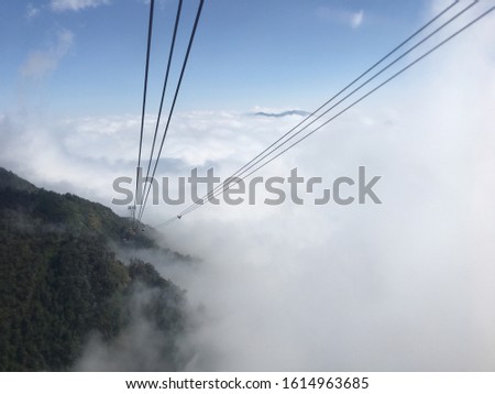 Arrival of a cableway in the mountains with cables that go down and get lost in the clouds.