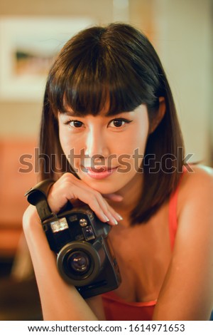 Beautiful asian woman is a professional photographer with old vintage camera. Selective focus 