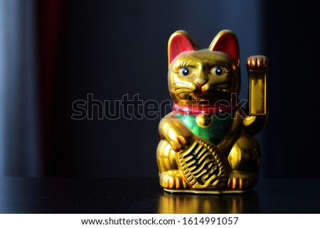 Golden Maneki Neko, the Lucky Cat, covered with dust. The concept of time and expectation of good luck Royalty-Free Stock Photo #1614991057