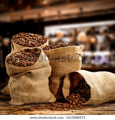 Fresh coffee beans in brown retro sacks and free space for your decoration.Dark interior of cafe and brown bar. Copy space and black shadows. 