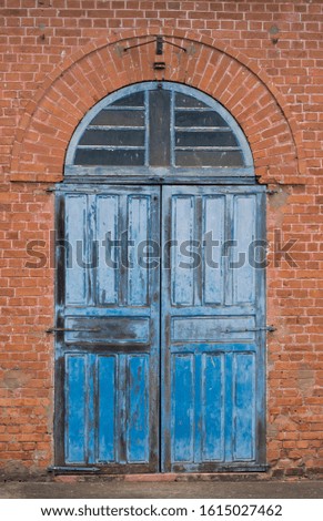 Old blue wood door against orange brick wall