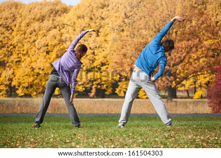  Couple doing exercises in park during autumn