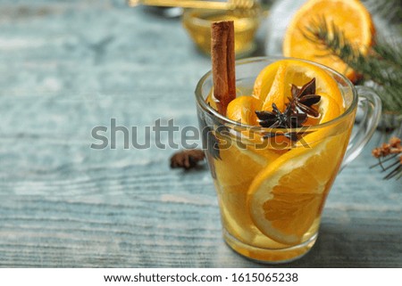 Aromatic mulled wine on light blue wooden table. Space for text