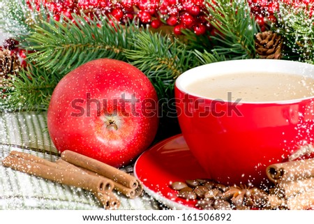 Coffee cup and red apple on the spruce background  and snowy frame