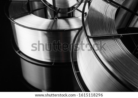 welding wire, stainless steel, on a black background Royalty-Free Stock Photo #1615118296