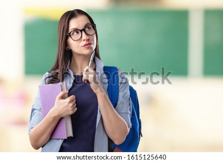 Beautiful school girl on classroom background. Education concept