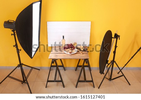 Cheese with wine and grapes on table in professional photo studio