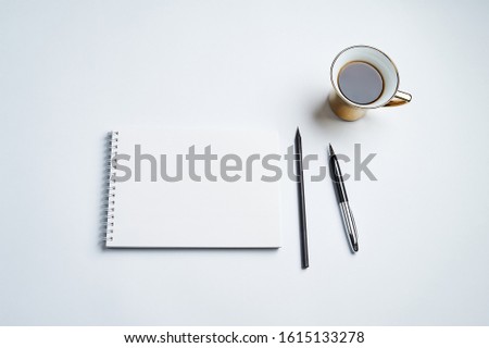 white office Desk top view with Notepad, pen, pencil and coffee Cup, minimalistic design, top view,copy space,flat lay
