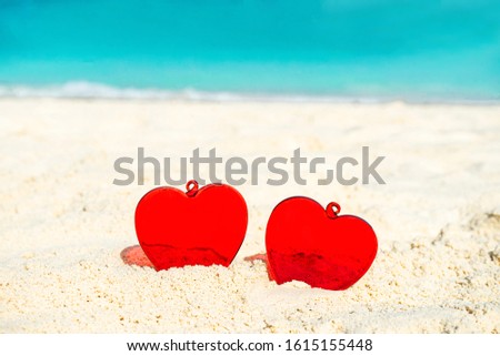 Red Heart shape on white yellow sand beach. Love concept for Valentine Day or summer vacation.