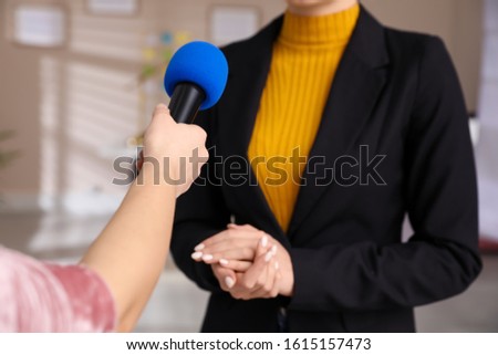 Professional journalist interviewing young woman in room, closeup