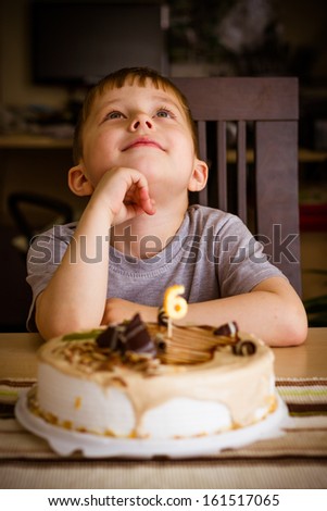 The boy looks at the birthday cake